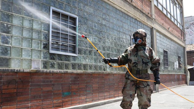 Un soldado fue registrado este sábado, durante una jornada de desinfección para evitar la propagación del COVID-19 en el parque del barrio 20 de julio, en Bogotá (Colombia). EFE/Carlos Ortega
