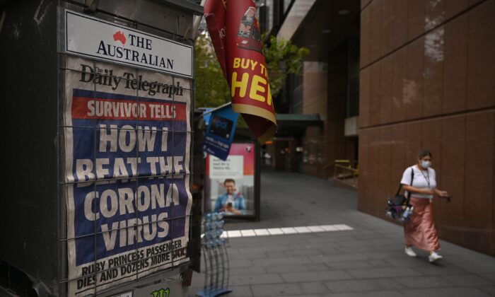 Un titular de periódico sobre el brote de coronavirus se ve en una calle casi desierta de Sydney el 30 de marzo de 2020. (PETER PARKS/AFP vía Getty Images)