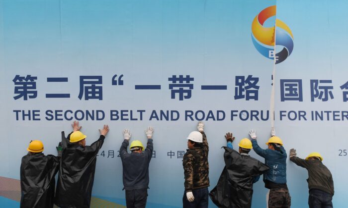 Trabajadores retiran un panel del Foro 'La Franja y la Ruta' fuera de una sede en Beijing el 27 de abril de 2019. (Greg Baker/AFP/Getty Images)