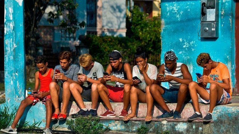 Jóvenes cubanos se conectan a Internet desde su teléfono móvil en La Habana, el 6 de junio de 2019. (YAMIL LAGE/AFP vía Getty Images)
