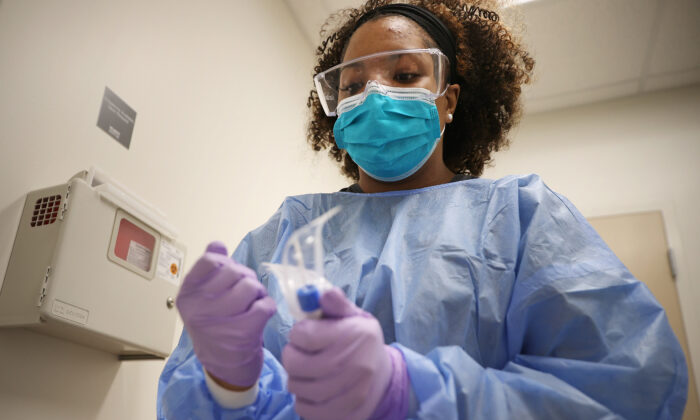 Un técnico en rayos X y la asistente médica Britni Chavis, se preparan para administrar la prueba el nuevo coronavirus en Woodbridge, Virginia, el 15 de abril de 2020. (Chip Somodevilla/Getty Images)