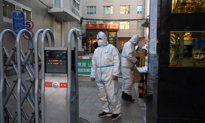 Los guardias de seguridad usan ropa de protección mientras esperan en la entrada de un restaurante en Beijing el 4 de marzo de 2020. (Greg Baker/AFP a través de Getty Images)