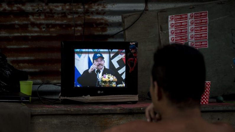 MANAGUA (NICARAGUA), 15/04/2020.- Un hombre observa la pantalla de un televisor en donde aparece el dictador de Nicaragua, Daniel Ortega, durante una transmisión de Cadena Nacional en Managua. Ortega reapareció en televisión, tras 34 días sin dar la cara en público en medio la pandemia por el coronavirus, y defendió la estrategia que ha adoptado el régimen y que, según dijo, le ha permitido contener el COVID-19 en nueve casos, con solo un fallecido. EFE/Jorge Torres
