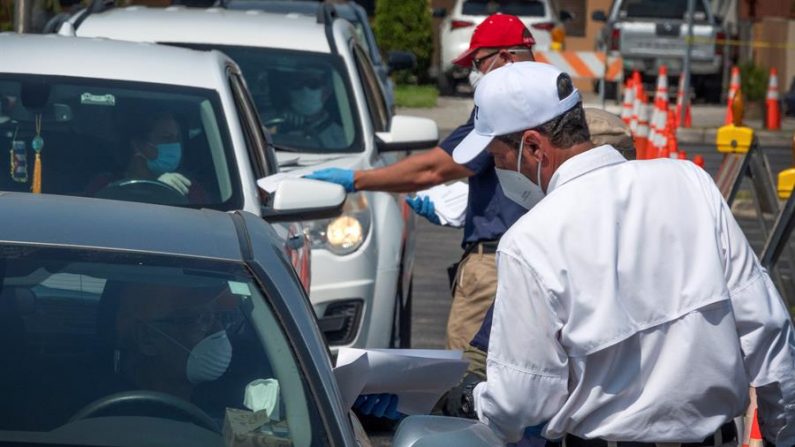 Un trabajador de la ciudad de Hialeah está entregando una solicitud impresa de beneficios de desempleo a los residentes de la ciudad en sus coches en Hialeah, Florida, EE.UU., 09 de abril 2020. EFE/EPA/CRISTOBAL HERRERA
