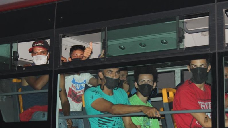 Hombres usando tapabocas abordan un autobús con un grupo de venezolanos para regresar a su hogar luego de cumplir con la cuarentena en la frontera con Colombia, en Ureña, Táchira (Venezuela). EFE/ Johnny Parra
