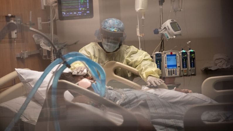 Enfermera cuida a paciente con COVID-19. Imagen Ilustrativa. (John Moore/Getty Images)