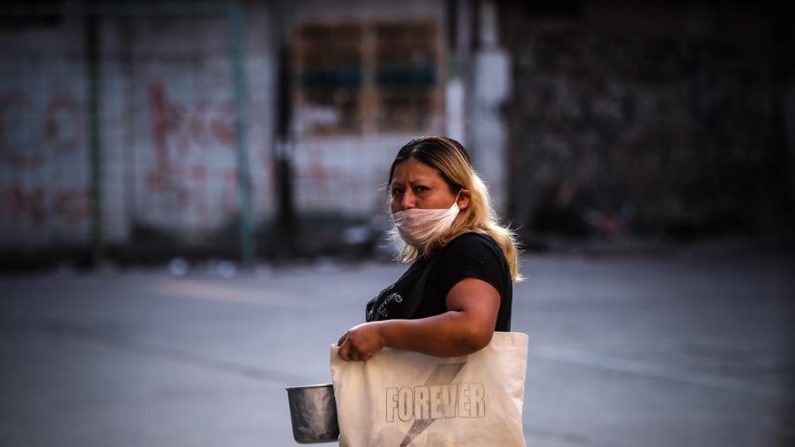 Personas necesitadas acuden a un comedor comunitario este miércoles, en un barrio humilde de Buenos Aires (Argentina). El país vive un momento de crisis social y económica como consecuencia del aislamiento obligatorio por el coronavirus. EFE/ Juan Ignacio Roncoroni
