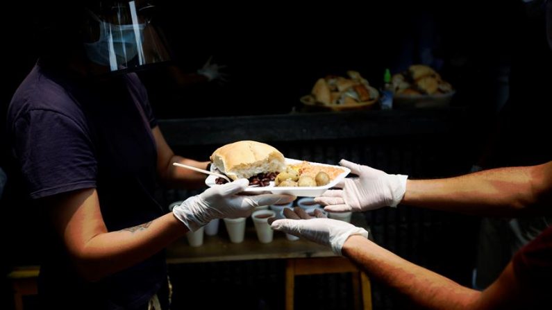 CIUDAD DE GUATEMALA (GUATEMALA), 15/04/2020.- Voluntarios con la ayuda del restaurante Rayuela crearon un sistema de cocina y entrega de alimentos a personas afectadas económicamente por las medidas de restricción y movilidad tomadas por el Gobierno para combatir el COVID-19 en el centro histórico de Ciudad de Guatemala. EFE/Esteban Biba
