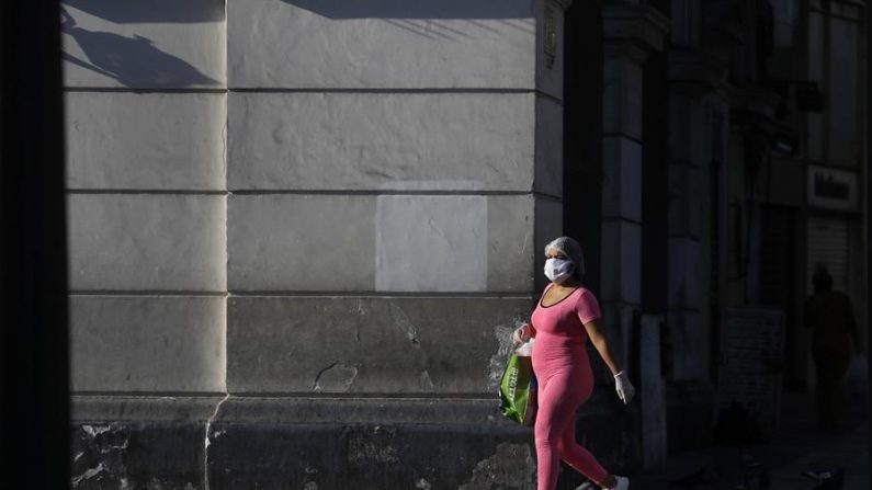 Una mujer camina por una vacía Plaza San Martín este lunes, en el centro histórico de Lima (Perú). EFE/Paolo Aguilar
