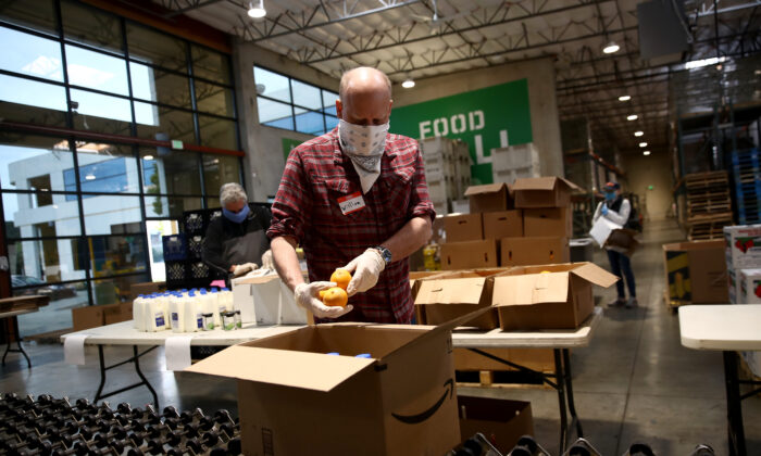 Voluntarios empacan cajas llenas de comida en el San Francisco-Marin Food Bank San Rafael, en California, el 18 de abril de 2020. (Ezra Shaw/Getty Images)