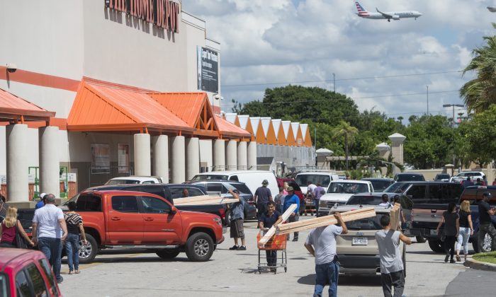 Las personas salen con suministros fuera de una tienda Home Depot en Miami, Florida, mientras se preparan para el huracán Irma, el 7 de septiembre de 2017. (SAUL LOEB/AFP/Getty Images)
