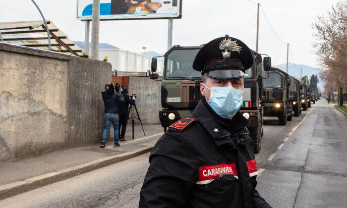 Un oficial de los Carabinieri bloquea el tráfico vehicular cuando un convoy de vehículos militares llega al Cementerio Monumental el 26 de marzo de 2020 en Bérgamo, cerca de Milán, Italia. (Emanuele Cremaschi/Getty Images)