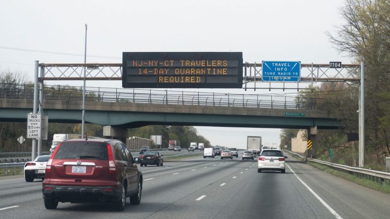 Automóviles circulan debajo de un letrero en la carretera que notifica a los viajeros de Nueva York, Nueva Jersey o Connecticut que deben permanecer en cuarentena durante 14 días, en Millersville, Maryland, el 17 de abril de 2020, en medio de la pandemia COVID-19. (Andrew Caballero-Reynolds/AFP a través de Getty Images)