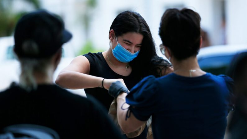 Un residente local recibe comida de las escuelas públicas del condado de Miami-Dade en Miami Beach, Florida, el 19 de abril de 2020. (Cliff Hawkins/Getty Images)