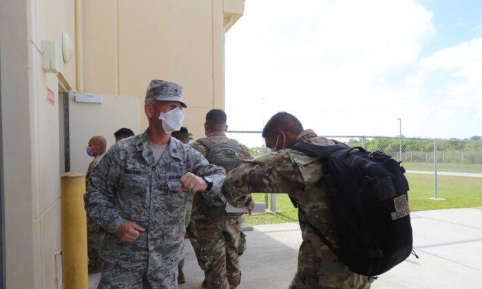 El mayor Dennis Kirkland, capellán estatal de la Guardia Nacional de Guam, saluda a los soldados que se preparan para sus chequeos a través de controles médicos y aduaneros, en el centro de preparación GUNG después de llegar a la isla, el 5 de abril de 2020. (Foto de la Guardia Nacional del Ejército de EE.UU. por JoAnna Delfin)