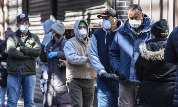 La gente hace fila con mascarillas en el barrio de Elmhurst en la Ciudad de Nueva York el 1 de abril de 2020. (Stephanie Keith/Getty Images)