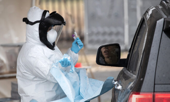 Una enfermera vestida con equipo de protección personal se prepara para dar una prueba de hisopado de COVID-19 en una estación de pruebas en Stamford, Connecticut, el 23 de marzo de 2020. (John Moore/Getty Images)