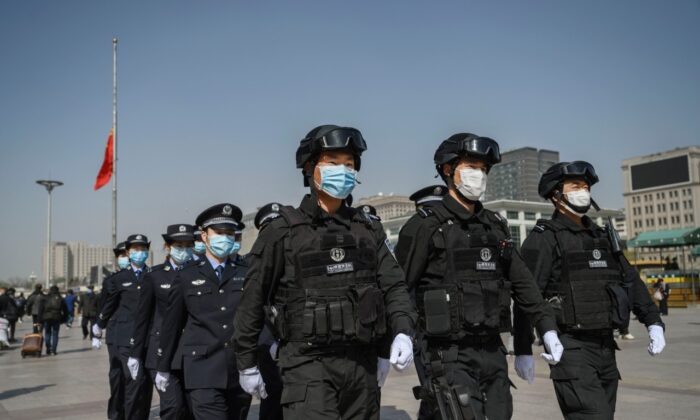 Oficiales de policía chinos marchan en formación en la Estación de Ferrocarril de Beijing el 4 de abril de 2020 en Beijing, China.(Kevin Frayer/Getty Images)