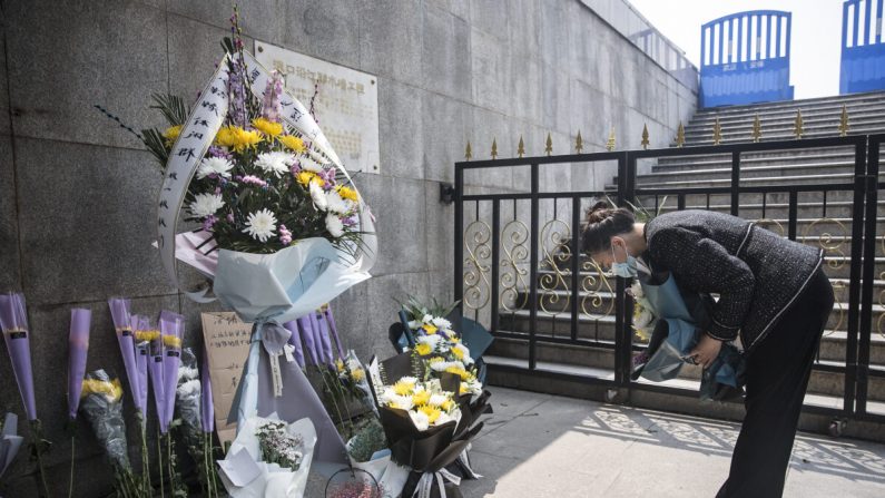 Una residente presenta flores durante un homenaje silencioso a los mártires que murieron en la lucha contra el nuevo brote de la enfermedad del coronavirus (COVID-19) y a los compatriotas que murieron por la enfermedad en Wuhan, provincia de Hubei, China, el 4 de abril de 2020. (Getty Images)