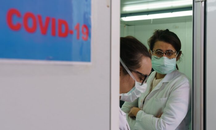 Trabajadores de la salud esperan en el área de detección externa del Hospital de Burgos, establecido para separar a los pacientes con síntomas sospechosos del virus del PCCh del resto de los pacientes antes de su admisión en Burgos, en el norte de España, el 2 de abril de 2020. (Cesar Manso/AFP/Getty Images)
