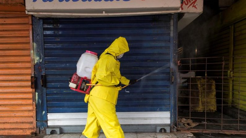 Fotografía fechada el 28 de mayo del 2020 donde se observan empleados gubernamentales en una jornada de saneamiento en el mercado "Las Pulgas", en Maracaibo (Venezuela). Una mujer que había dado negativo en una prueba rápida de detección del nuevo coronavirus falleció poco después por COVID-19, informó este viernes el ministro de Comunicación, Jorge Rodríguez. EFE/ Henry Chirinos
