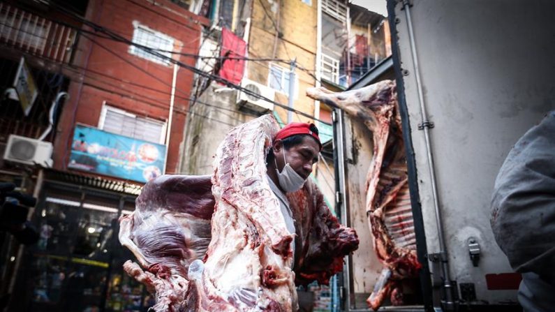 Un trabajador descarga carne este viernes de un camión en la Villa 31, en Buenos Aires (Argentina). La capital argentina y la provincia que la circunda registran el mayor número de contagios en dicho país, con 1.924 casos en la provincia de Buenos Aires y 1.583 en la ciudad de Buenos Aires, según un reporte del Ministerio de Salud. EFE/Juan Ignacio Roncoroni
