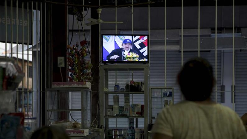 Dos mujeres observan en la pantalla de un televisor en una tienda de abarrotes al dictador de Nicaragua, Daniel Ortega, durante una transmisión de Cadena Nacional en Managua. EFE/Jorge Torres/Archivo

