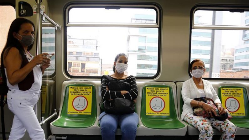 Un grupo de personas con tapabocas guarda distanciamiento social, según las indicaciones del metro de Medellín, durante la cuarentena nacional para contener la expansión de la COVID-19, este jueves, en Medellín (Colombia). EFE/Luis Eduardo Noriega
