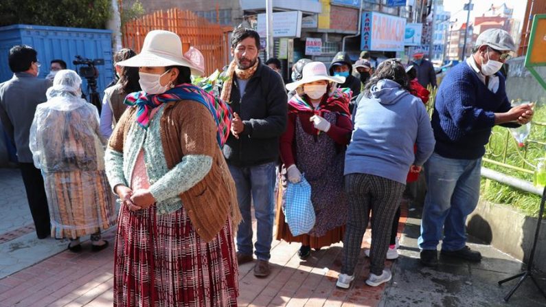 Un grupo de personas hacen fila para utilizar una cámara de medicina tradicional, donde usan plantas de eucalipto, manzanilla y huira huira, que tienen cualidades "expectorantes" y que ayudan a las vías respiratorias, en El Alto, Bolivia. EFE/Martin Alipaz/Archivo
