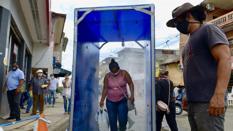 Personas pasan por un túnel desinfectante el 12 de mayo de 2020 en Daule, en la provincia de Guayas (Ecuador). EFE/Marcos Pin
