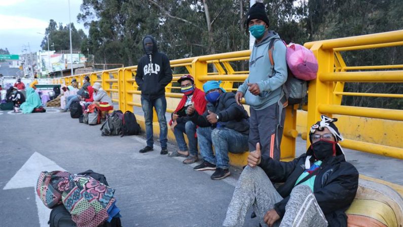 Fotografía cedida por la Prefectura de Carchi ciudadanos venezolanos posando en el lado ecuatoriano del puente Rumichaca que separa a Ecuador de Colombia, el 29 de abril de 2020. EFE/Xavier Montalvo
