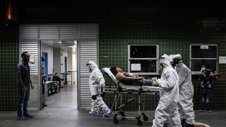 Trabajadores del Servicio de Atención Médica de Urgencia de Brasil (SAMU) trasladan a una paciente con covd-19 al hospital este jueves, en Manaos, estado de Amazonas (Brasil). EFE/Raphael Alves
