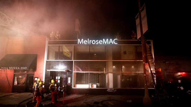 Los bomberos inspeccionan la tienda MelroseMAC que fue asaltada y saqueada después de un día de protesta durante el cual miles de manifestantes tomaron la calle para manifestarse tras la muerte de George Floyd, en Los Ángeles, California, EE.UU., el 30 de mayo de 2020. EFE/EPA/ETIENNE LAURENT
