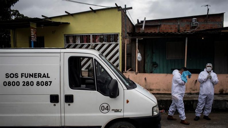 Técnicos del programa "SOS Funeral" de la Secretaría Municipal de Asistencia Social, trasladan el cuerpo de José Guy Barreto de su casa este jueves, en el barrio Jorge Teixeira, en Manaos (Brasil). EFE/Raphael Alves
