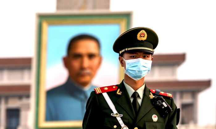 Una policía china con mascarilla protectora marcha frente al retrato del fundador nacionalista Sun Yat-sen en la Plaza de Tiananmen en Beijing, China, el 28 de abril de 2020. (Lintao Zhang/Getty Images)