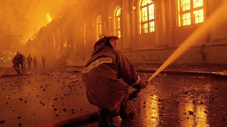 Los bomberos rocían agua sobre el enorme incendio que engulló la sala de exposiciones de Manezh cerca del Kremlin en el centro de Moscú, Rusia, a finales del 14 de marzo de 2004. (VLADIMIR SUVOROV/AFP a través de Getty Images)