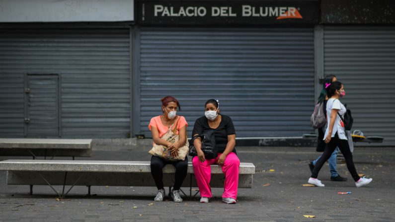La gente, usa máscaras faciales mientras descansa en el bulevar de Sabana Grande, en Caracas (Venezuela), el 14 de mayo de 2020 en medio del brote del virus del PCCh. (FEDERICO PARRA/AFP vía Getty Images)