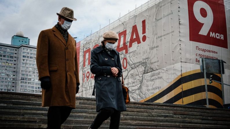 Una pareja con máscaras faciales, en medio de las preocupaciones del COVID-19, camina en el centro de Moscú el 7 de mayo de 2020. (DIMITAR DILKOFF/AFP vía Getty Images)