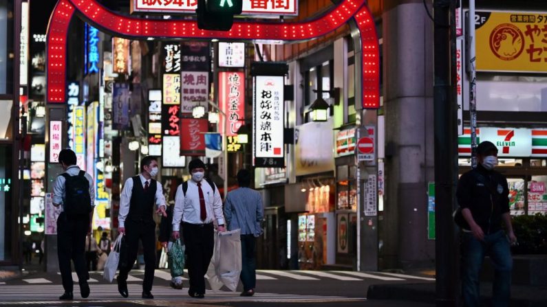 Las personas que llevan mascarillas en medio de la preocupación por la propagación del COVID-19 cruzan una calle de Tokio (Japón) el 4 de mayo de 2020. (CHARLY TRIBALLEAU/AFP vía Getty Images)