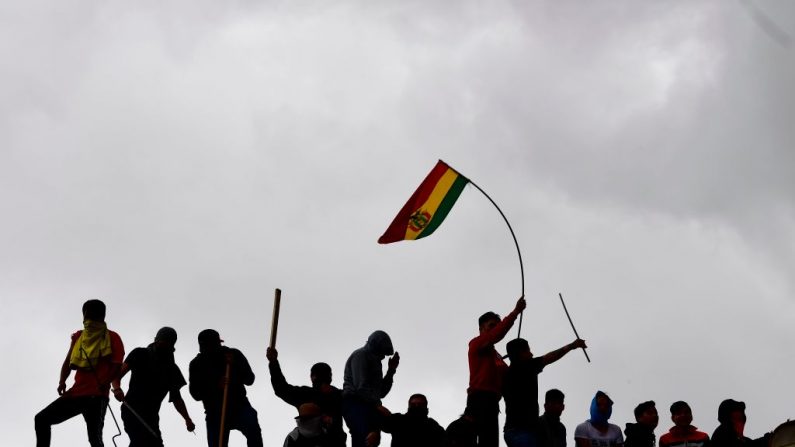 Prisioneros ondean banderas nacionales bolivianas mientras permanecen en el techo de una prisión el 12 de noviembre de 2019. (Foto de RONALDO SCHEMIDT/AFP vía Getty Images)
