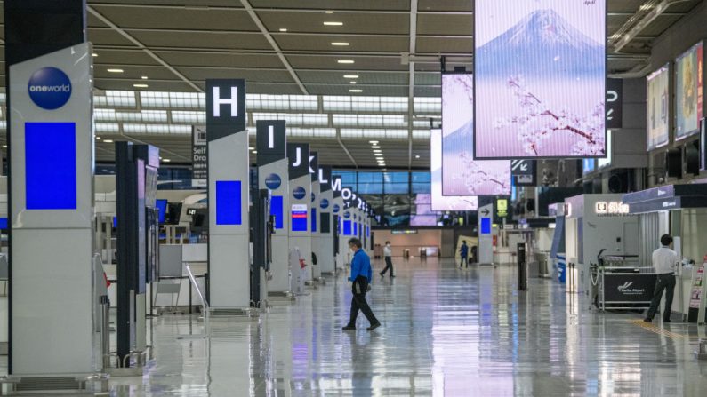 El personal camina por una terminal casi vacía del aeropuerto de Narita el 17 de abril de 2020 en Tokio, Japón. (Carl Court/Getty Images)