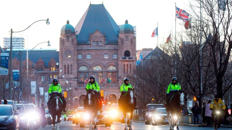 Oficiales de la policía montada recorren la avenida University a través de la fila de hospitales mientras los socorristas de Toronto desfilan frente a los hospitales de Toronto, Ontario (Canadá), en un saludo a los trabajadores de la salud el 19 de abril de 2020, durante la pandemia del nuevo coronavirus. (Foto de COLE BURSTON/AFP a través de Getty Images)