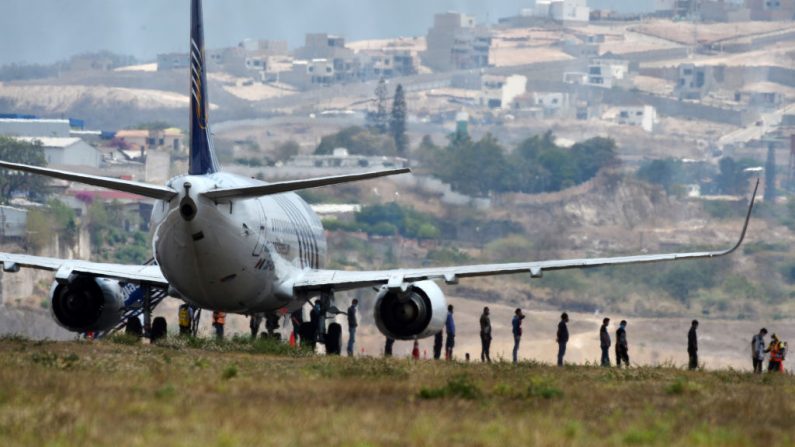 Unos 136 migrantes hondureños descienden de un avión en el Aeropuerto Internacional de Toncontin, en Tegucigalpa (Honduras), el 25 de abril de 2020 a su llegada deportados de México y enviados a la cuarentena en medio de la pandemia de COVID-19. (ORLANDO SIERRA/AFP vía Getty Images)