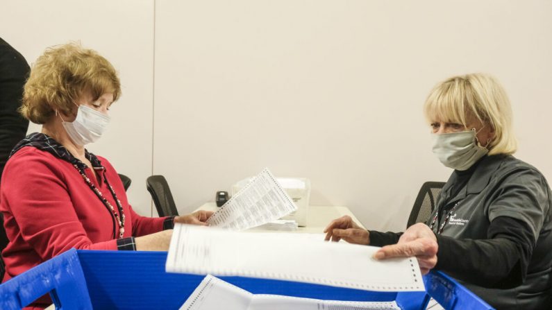 Empleados y voluntarios de la Junta de Elecciones del Condado de Franklin clasifican y desempacan tanto las boletas por correo como las boletas provisionales en Columbus, Ohio, el 28 de abril de 2020. (Matthew Hatcher/Getty Images)