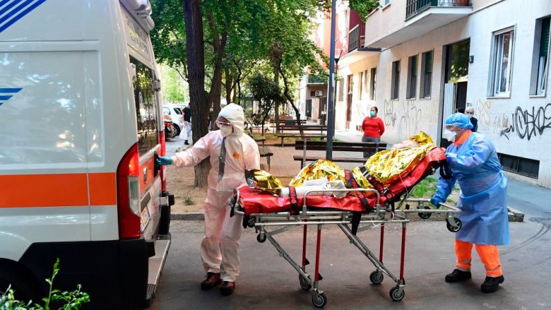 Los socorristas de la Asociación Voluntaria Italiana de Primeros Auxilios y Asistencia Pública "Croce Bianca", Sara Gramegna y Mauro Tominetti (d), llevan a un paciente a una ambulancia en Milán (Italia) el 29 de abril de 2020, durante el cierre del país con el fin de frenar la propagación de la infección COVID-19, causada por el virus del PCCh. (MIGUEL MEDINA/AFP vía Getty Images)