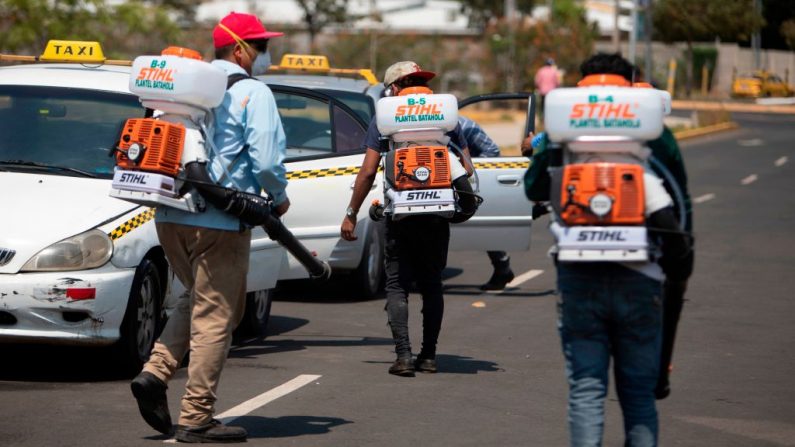 Los empleados de la Municipalidad de Managua (Nicaragua) desinfectan los taxis como medida de precaución contra la propagación del virus del PCCh en el Estadio Nacional Dennis Martínez de Managua el 30 de abril de 2020. (INTI OCON/AFP vía Getty Images)