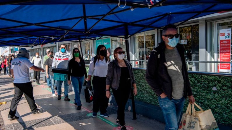 La gente hace cola para entrar a un centro comercial durante su reapertura después del brote del virus del PCCh, en Santiago (Chile) el 30 de abril de 2020. (MARTIN BERNETTI/AFP vía Getty Images)