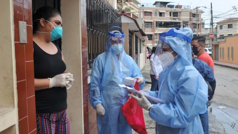 Los trabajadores de la salud se preparan para hacer una prueba rápida de COVID-19 a una mujer en el norte de Guayaquil, Ecuador, el 30 de abril de 2020. (JOSE SANCHEZ LINDAO/AFP vía Getty Images)