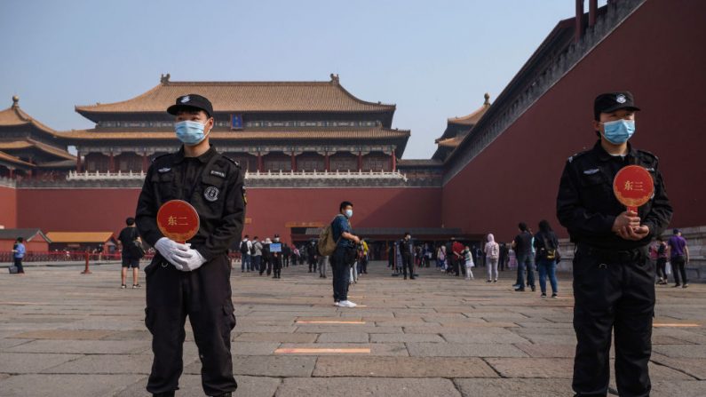 Guardias chinos usan máscaras protectoras mientras están parados en la entrada de la Ciudad Prohibida, el 1 de mayo de 2020, en Beijing, China. (Kevin Frayer/Getty Images)
