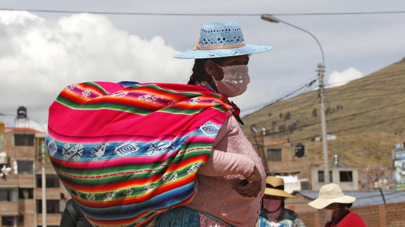 Una indígena asiste a un mercado callejero en Puno, Perú, cerca de la frontera con Bolivia, el 1 de mayo de 2020, a pesar de la regulación para evitar eventos multitudinarios para evitar la propagación del virus del PCCh. (JUAN CARLOS CISNEROS/AFP vía Getty Images)